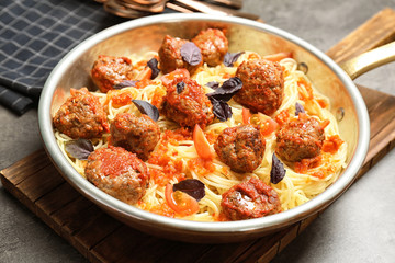 Delicious pasta with meatballs and tomato sauce in frying pan