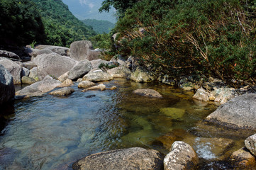 Naklejka na ściany i meble Photo of a mountain river in China among large stones.