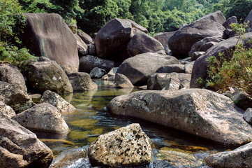 Photo of a mountain river in China among large stones.