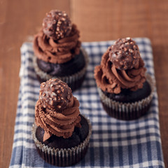 Tasty chocolate cupcakes on wooden board. Rustic style