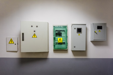 Metal and plastic electric breaker boxes with yellow electrical warning signs of danger  high...