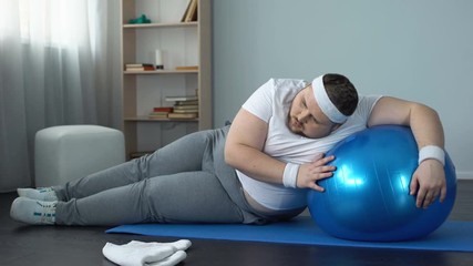 Obese male struggling to finish home workout program, fitness routine, goal
