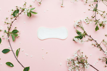 The sanitary napkin lying with blossom on pink background.