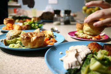 Roast dinners ready to serve while a hand steals a Yorkshire pudding