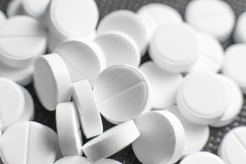 White pills on black background closeup
