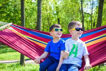 Brother and boy relaxing in hammock at vacation