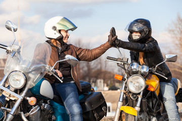 Clapping hands in leather gloves while greeting each other on urban road in partnership