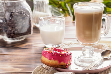 Cup of hot coffee latte beverages with donut glazed