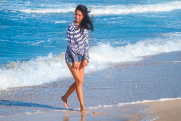 cheerful joyful woman running along the beach, the concept of vacation and travel