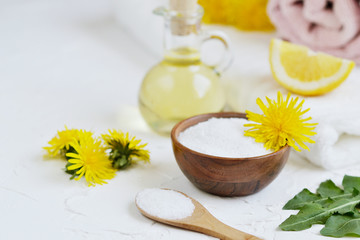 Natural ingredients for homemade body salt scrub with dandelion flowers, lemon, honey and olive oil, SPA concept, white background