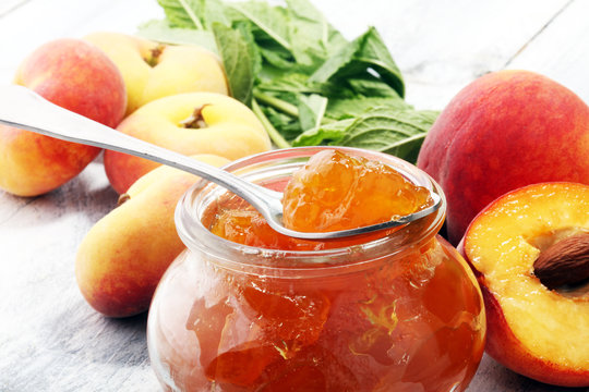 Peach vanilla jam with fresh peaches on table.