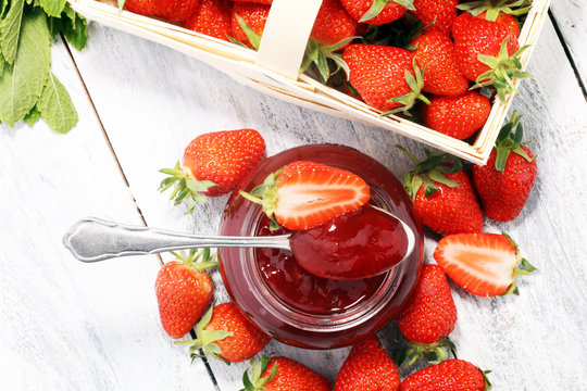 Strawberry jam in a jar and fresah strawberries.