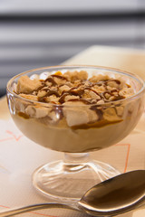 Sweet dessert with cookies and caramel on cup of glass with silver spoon