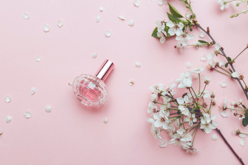 Women's hand spray perfume. Flower arrangement. Flowers, fragrance, perfume on pink background