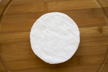 Cheese camembert on bamboo board. Food for wine. From above. Top view.