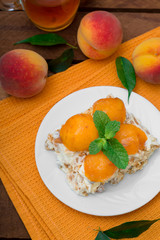 Cake with diced peach, whipped cream and mint. Wooden rustic background. Top view