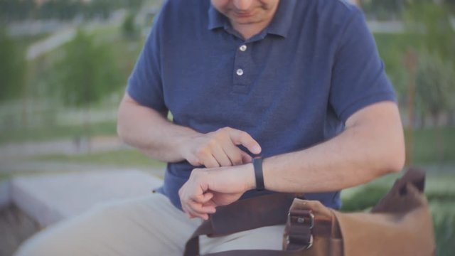 A man checks with the help of smart hours the number of steps per day