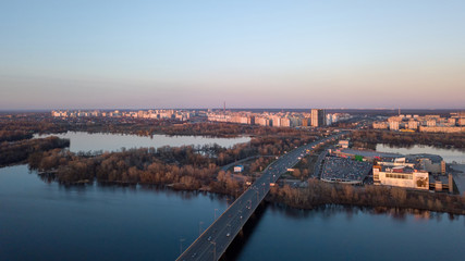 Fototapeta na wymiar Dnieper river with bridge, Shopping center Skymol, parking and Truhaniv island from above in Kyiv, Ukraine