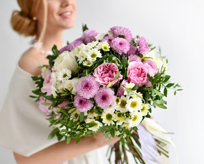 Naklejka premium Beautiful woman hold bouquet of chrysanthemum and roses flowers white and purple happy smiling on grey 