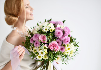 Beautiful woman hold bouquet of chrysanthemum and roses flowers white and purple happy smiling on grey 