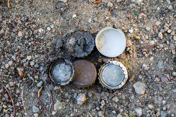 Old cap on the path in the park. Satre Metal closures from beverage bottles.
