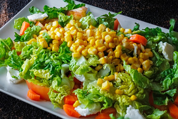 Mediterranean Fresh salad. Set of vegetables with lettuce, maize, tomato, cheese and carrot. Tasty and appetizing Mediterranean diet