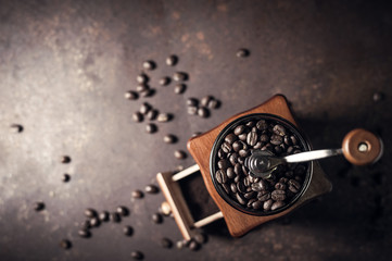 Beautiful coffee grinder and coffee bean on old kitchen table background.