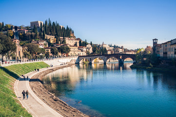 Bend of the Adige river that crosses Verona (Italy) and view of the stone bridge and San Pietro castle. - 204009101