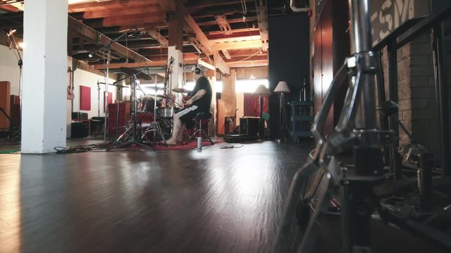 Side Angle of Drummer in Recording Studio. shot moves in and back from drum equipment to show a drummer in a recording studio