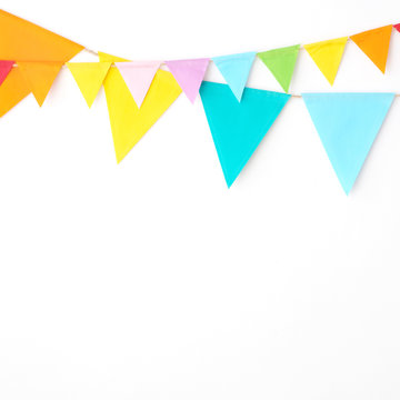 Colorful party flags hanging on white wall  background, birthday, anniversary, celebrate event, festival greeting card background