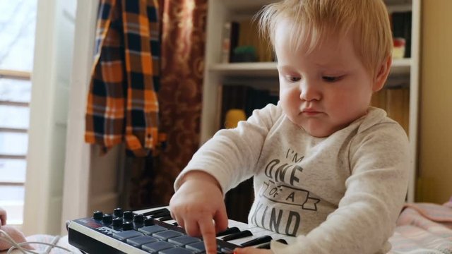 one year old excited baby boy using akai mpk mini device young male musician developing musical talent portrait at home sweet innocence playing playful cheerful child