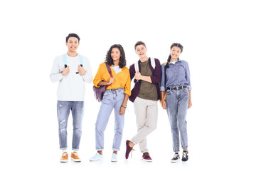 smiling interracial students with backpacks isolated on white