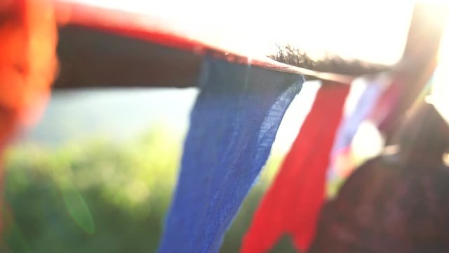 Close up of a buddhist prayer flags blowing in the wind at sunrise in a temple in Sri Lanka. Slow Motion Footage. Shallow depth of field,