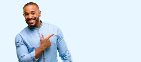 African american man with beard pointing away side with finger isolated over blue background