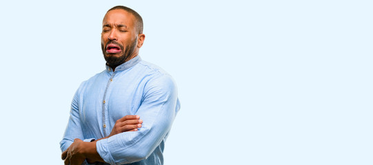 African american man with beard crying depressed full of sadness expressing sad emotion isolated over blue background