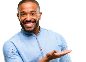 African american man with beard holding something in empty hand isolated over white background