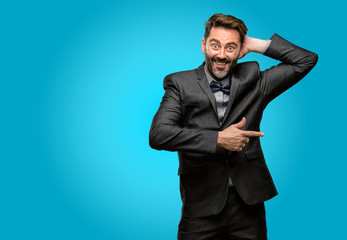 Middle age man, with beard and bow tie pointing away side with finger