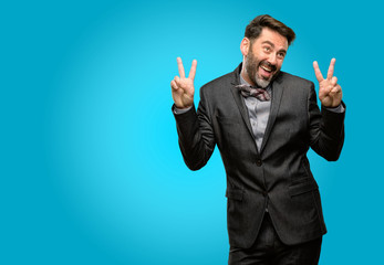 Middle age man, with beard and bow tie happy and excited expressing winning gesture. Successful and celebrating victory, triumphant