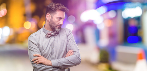 Fototapeta premium Middle age man, with beard and bow tie irritated and angry expressing negative emotion, annoyed with someone at night club