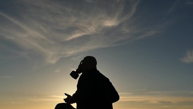 man in gas mask ritual exercise isolated silhouette slow motion