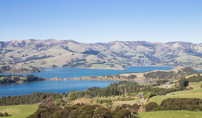 Naklejka na ściany i meble Landscape view of the rolling hills and harbour of Akaroa, Banks Peninsular, New Zealand.