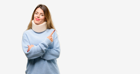 Young injured woman wearing neck brace collar pointing away side with finger