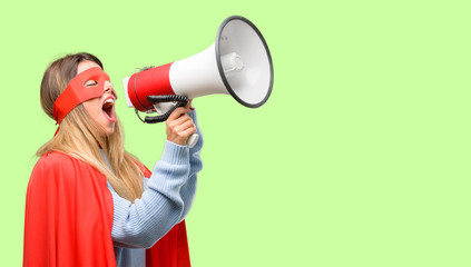 Young super woman communicates shouting loud holding a megaphone, expressing success and positive concept, idea for marketing or sales