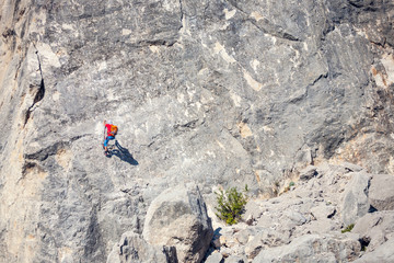 The climber is hanging on a rope.