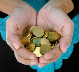 A female hand with coin isolated against a white background