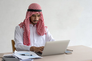 Picture of Arabian handsome man using modern laptop typing message on a laptop computer with...