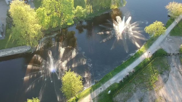 Two beautiful working fountains on spring river in city park, aerial view