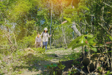 Obraz na płótnie Canvas Family, Mom and Son on a hiking along the path throught forest with sunny in summer.