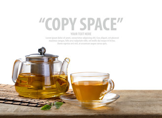 Warm cup of tea and glass jars with organic green tea leaf on wooden table isolate white background with copy space
