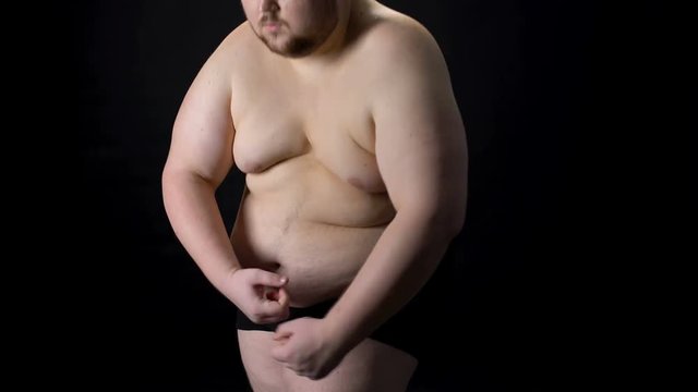 Excess weight male posing pretending to be muscular, cellulite and stretch marks